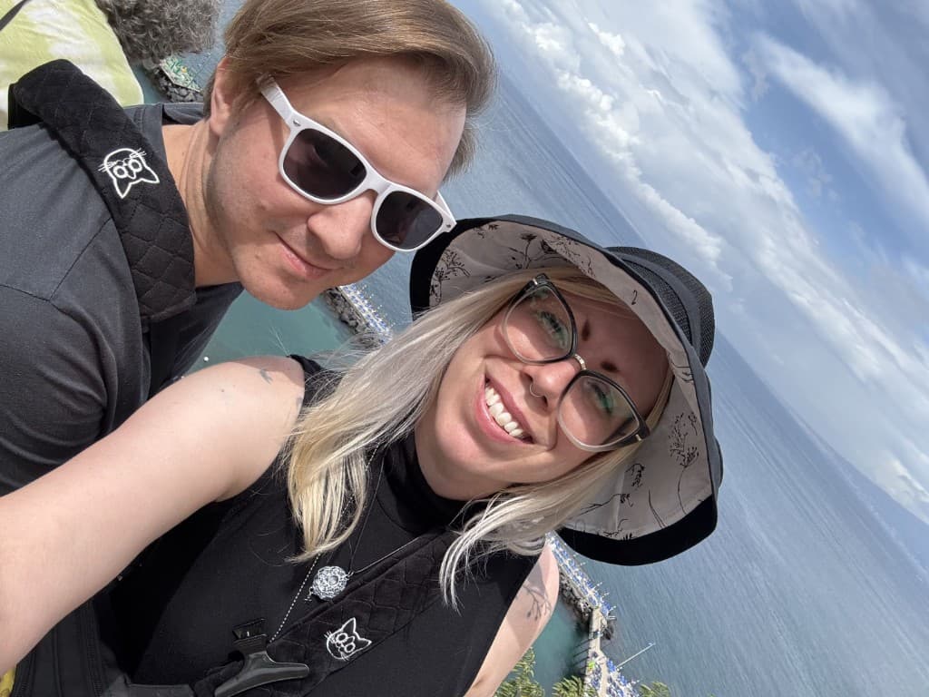 Dan and Madison taking a selfie outdoors in Sorrento, blue water and sky behind them with Mount Vesuvius in the distance
